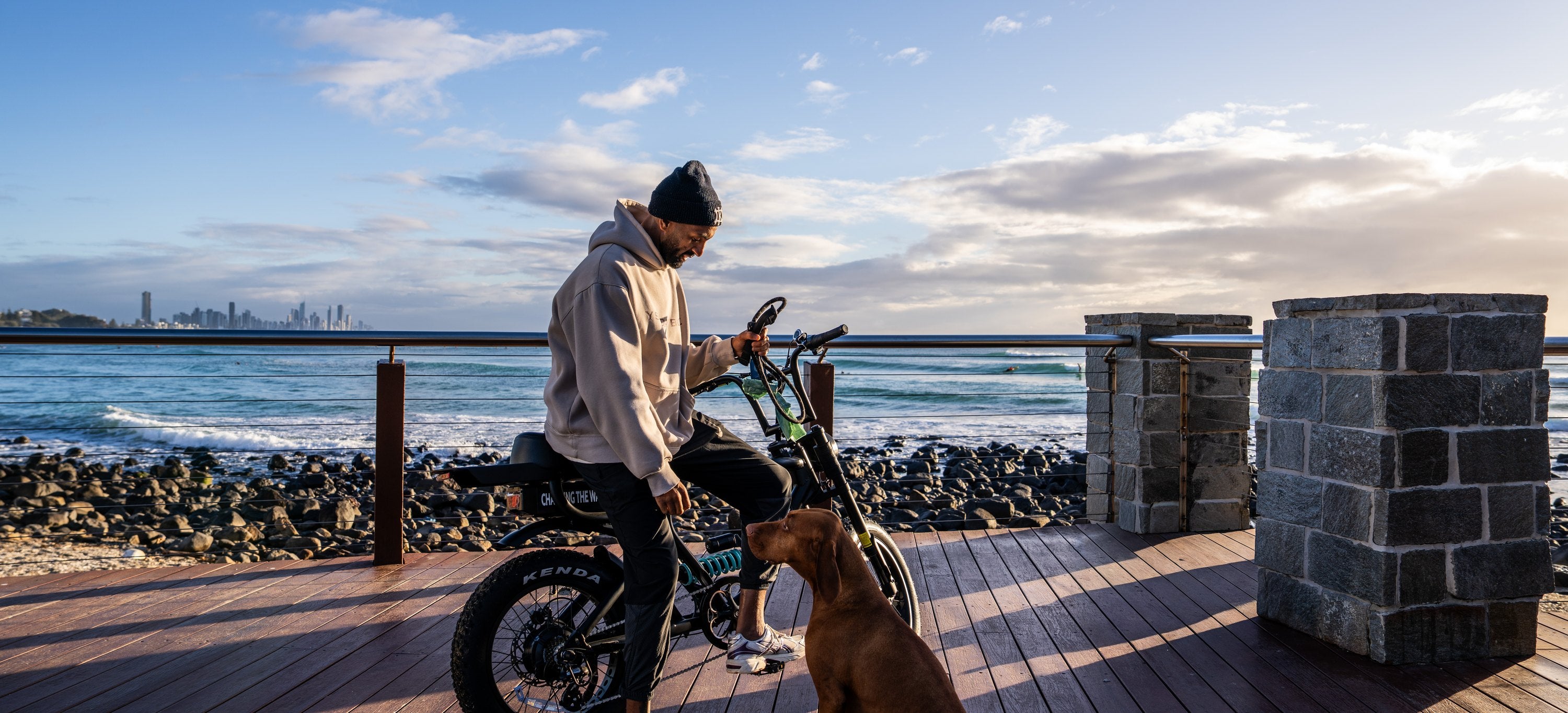 A rider and his dog beside the Rolls on the Burleigh boardwalk at sunrise