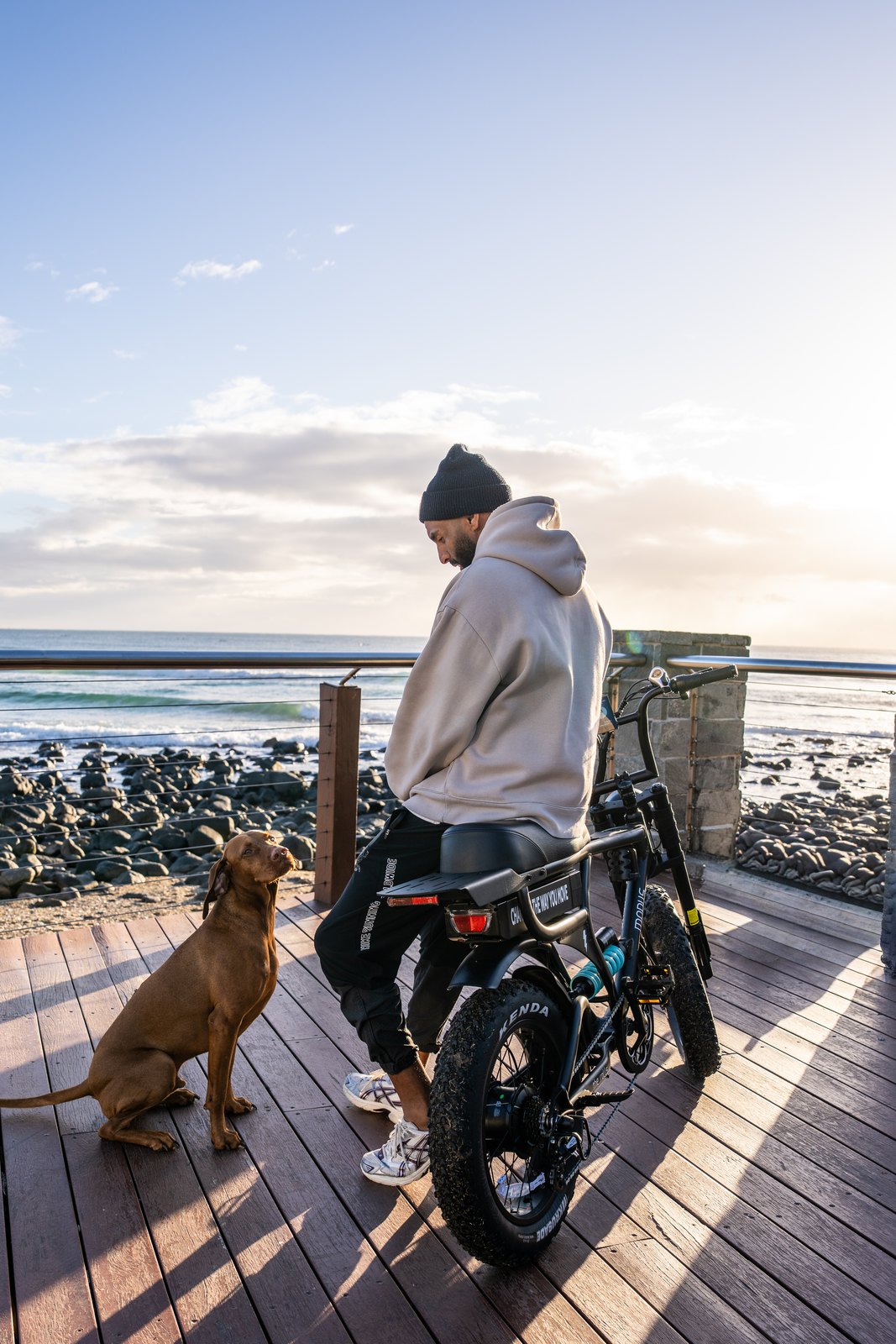 A rider and his dog beside the Rolls on the Burleigh Heads boardwalk at sunrise