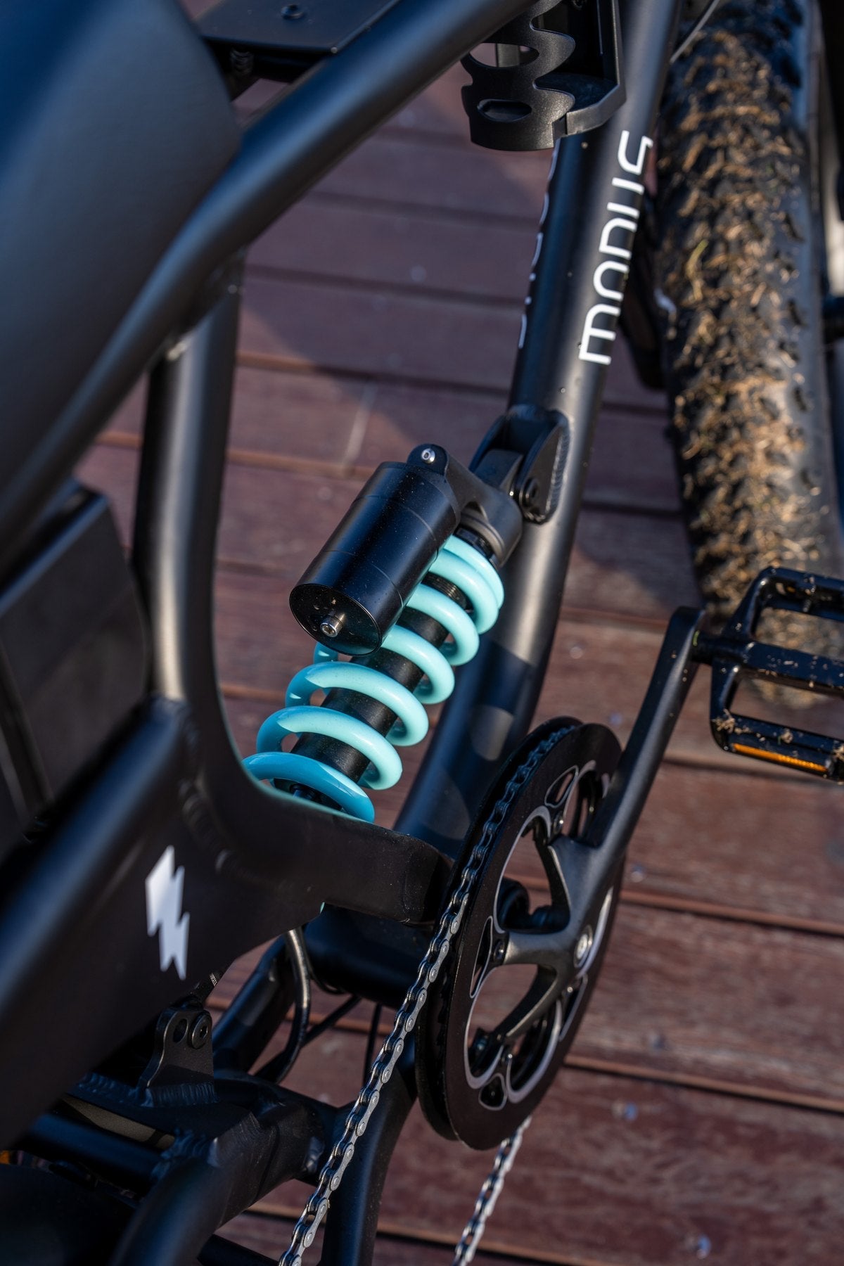 Close up of the teal DNM coil rear shock and cranks on the Rolls